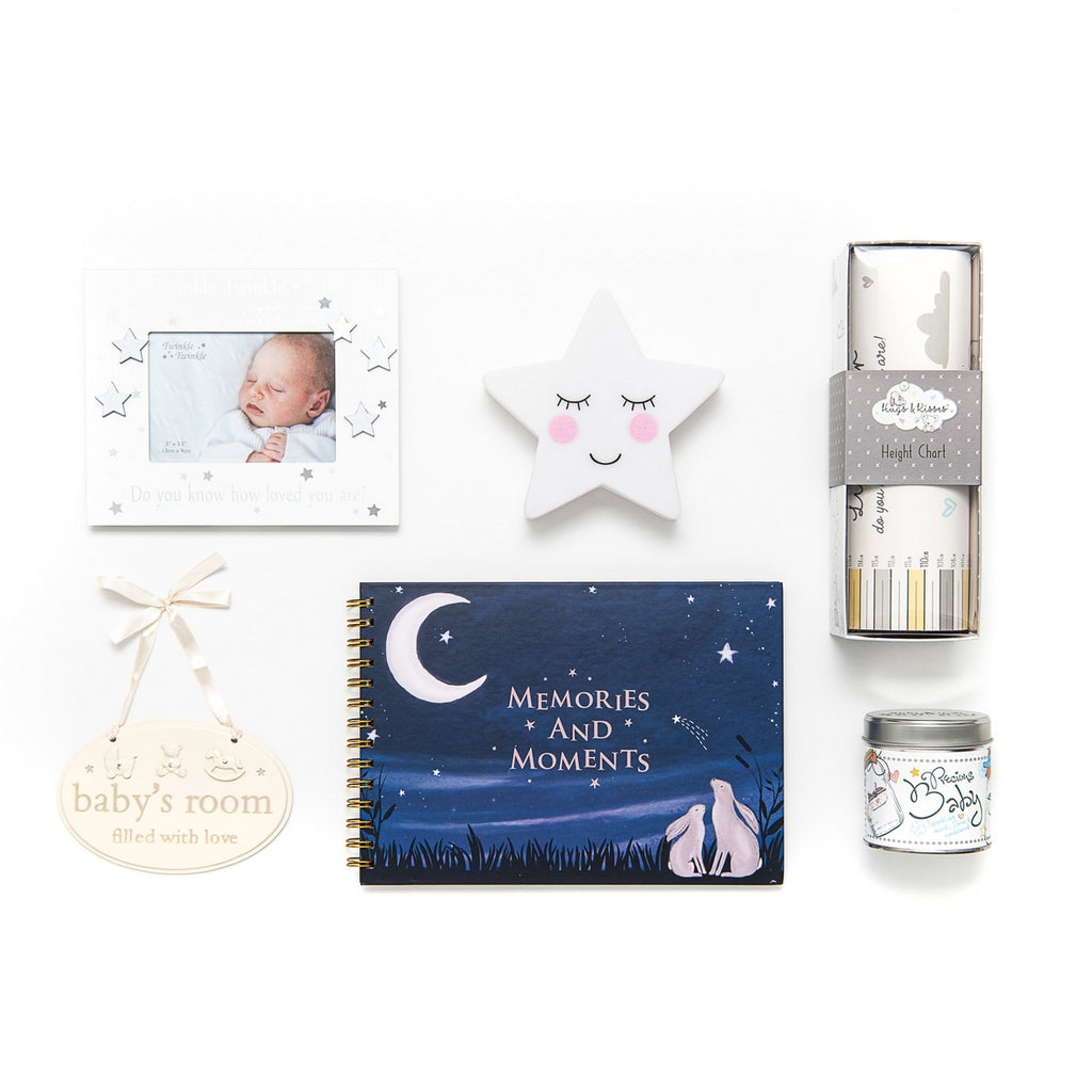 A selection of gifts in a box for the nursery.  Including a height chart, night light, first picture frame, keepsake memories book and scented candle