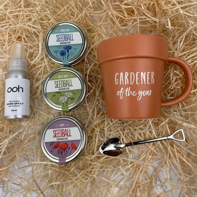 A garden lovers dream gift box. With 3 tins of ready to sow seed balls with easy to grow meadow blooms,  combined with a quirky plant pot shaped mug and shovel shaped spoon and hand sanitiser.